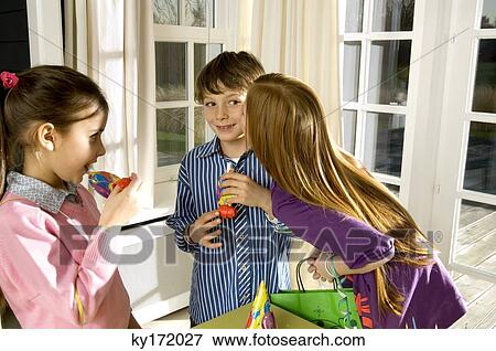 Girl kissing a boy and her friend looking at them View Large Photo Image Stock Photo - Girl kissing a boy and her friend looking at them. Fotosearch