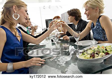 Group of people toasting with champagne at a dinner party View Large Photo Image Stock Image - Group of people toasting with champagne at a dinner party. Fotosearch