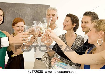 Group of people toasting with wine glasses in a party View Large Photo Image Stock Photo - Group of people toasting with wine glasses in a party. Fotosearch