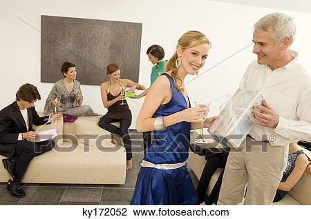 Mature man giving a gift to a young woman in a party View Large Photo Image Stock Image - Mature man giving a gift to a young woman in a party. Fotosearch