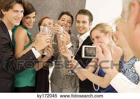 Mature man taking a picture of a group of people toasting with wine glasses in a party View Large Photo Image Stock Photography - Mature man taking a picture of a group of people toasting with wine glasses in a party. Fotosearch