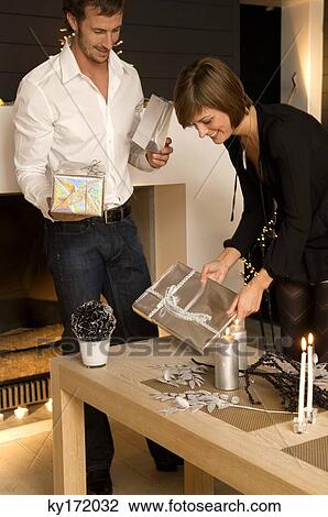 Mid adult man and a young woman holding Christmas presents View Large Photo Image Stock Image - Mid adult man and a young woman holding Christmas presents. Fotosearch