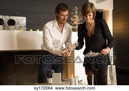 Mid adult man and a young woman celebrating Christmas View Large Photo Image Picture - Mid adult man and a young woman celebrating Christmas. Fotosearch