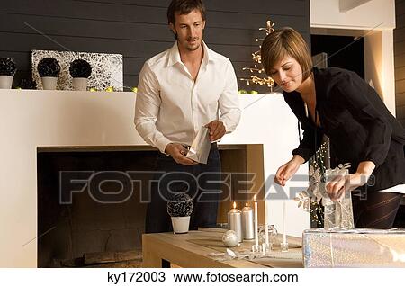 Stock Image - Mid adult man and a young woman celebrating Christmas. Fotosearch
