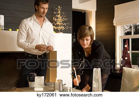 Mid adult man and a young woman celebrating Christmas View Large Photo Image Stock Image - Mid adult man and a young woman celebrating Christmas. Fotosearch