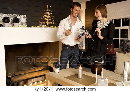 Mid adult man and a young woman celebrating Christmas View Large Photo Image Stock Image - Mid adult man and a young woman celebrating Christmas. Fotosearch