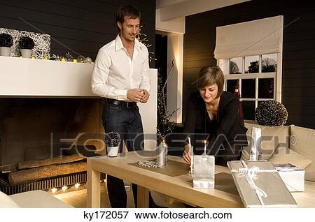 Mid adult man and a young woman celebrating Christmas View Large Photo Image Stock Photo - Mid adult man and a young woman celebrating Christmas. Fotosearch