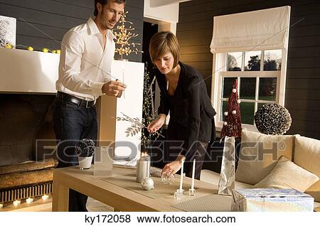 Mid adult man and a young woman celebrating Christmas View Large Photo Image Stock Photo - Mid adult man and a young woman celebrating Christmas. Fotosearch