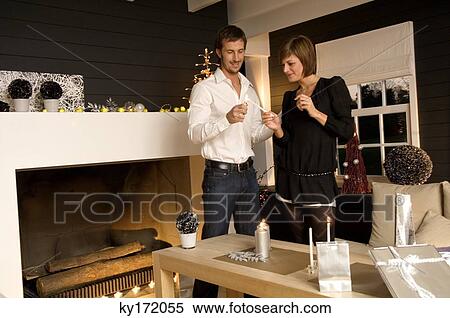 Mid adult man and a young woman lighting a candle with a cigarette lighter View Large Photo Image Stock Photography - Mid adult man and a young woman lighting a candle with a cigarette lighter. Fotosearch