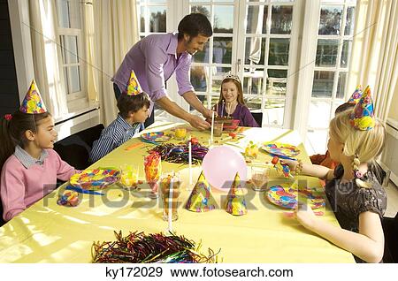 Stock Photo - Mid adult man celebrating his daughter's birthday. Fotosearch
