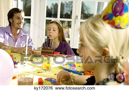 Mid adult man celebrating his daughter's birthday View Large Photo Image Stock Photograph - Mid adult man celebrating his daughter's birthday. Fotosearch