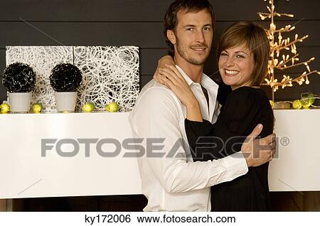 Portrait of a mid adult man and a young woman embracing each other and smiling View Large Photo Image Stock Photograph - Portrait of a mid adult man and a young woman embracing each other and smiling. Fotosearch