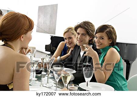 Stock Photo - Portrait of a teenage boy with his friends at a dinner party. Fotosearch