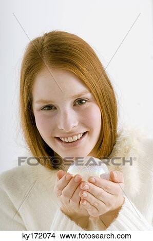 Picture - Portrait of a young woman holding a crystal ball and smiling. Fotosearch