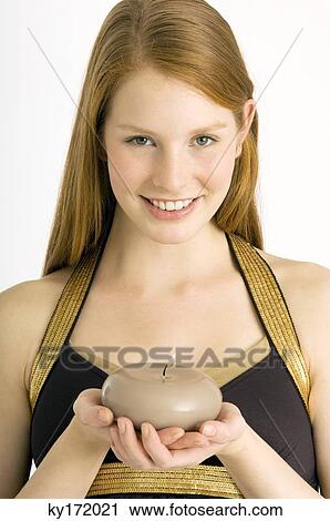 Portrait of a young woman holding a burning candle and smiling View Large Photo Image Stock Image - Portrait of a young woman holding a burning candle and smiling. Fotosearch