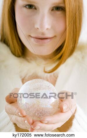 Stock Photography - Portrait of a young woman holding a crystal ball. Fotosearch