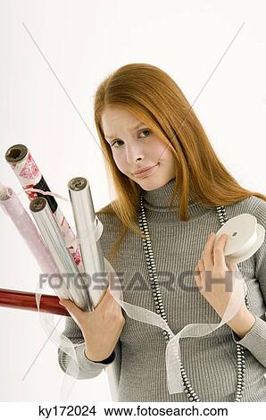 Portrait of a young woman holding rolls of wrapping papers View Large Photo Image Picture - Portrait of a young woman holding rolls of wrapping papers. Fotosearch