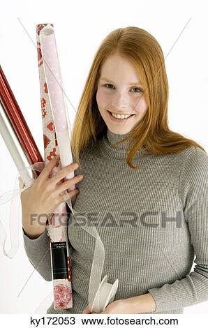 Portrait of a young woman holding rolls of wrapping papers and smiling View Large Photo Image Stock Image - Portrait of a young woman holding rolls of wrapping papers and smiling. Fotosearch