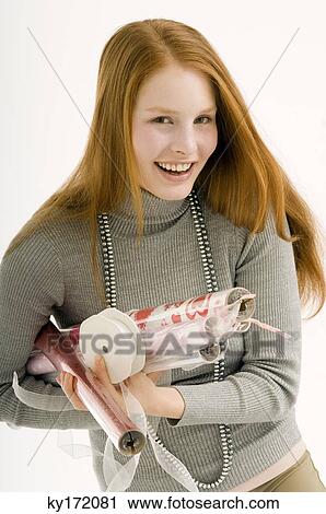 Portrait of a young woman holding rolls of wrapping papers and smiling View Large Photo Image Stock Image - Portrait of a young woman holding rolls of wrapping papers and smiling. Fotosearch