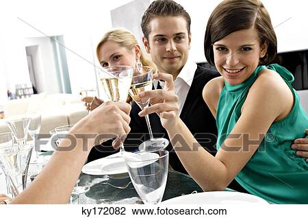 Portrait of a young woman toasting with champagne at a dinner party View Large Photo Image Stock Image - Portrait of a young woman toasting with champagne at a dinner party. Fotosearch