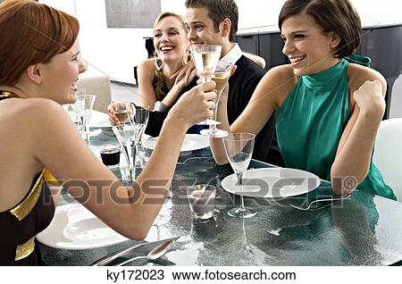 Two young women toasting with champagne at a dinner party View Large Photo Image Stock Image - Two young women toasting with champagne at a dinner party. Fotosearch