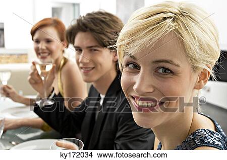 Two young women with a teenage boy at a dinner party View Large Photo Image Picture - Two young women with a teenage boy at a dinner party. Fotosearch