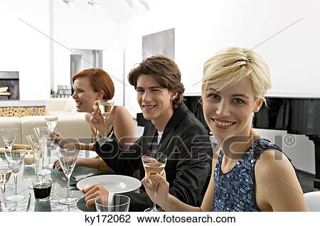Two young women with a teenage boy at a dinner party View Large Photo Image Stock Image - Two young women with a teenage boy at a dinner party. Fotosearch