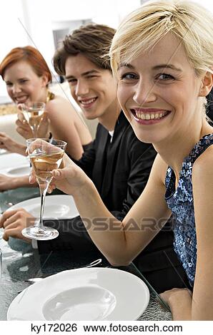 Two young women with a teenage boy at a dinner party View Large Photo Image Stock Photograph - Two young women with a teenage boy at a dinner party. Fotosearch