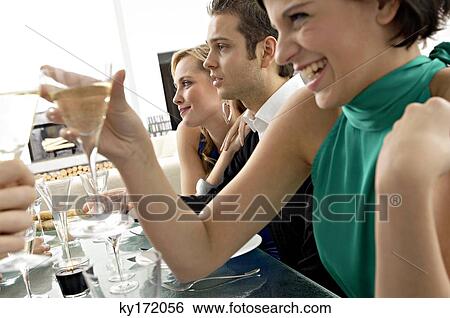 Young woman toasting with champagne at a dinner party View Large Photo Image Stock Photograph - Young woman toasting with champagne at a dinner party. Fotosearch