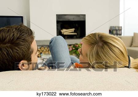 Close-up of a young couple sitting on a couch View Large Photo Image Stock Image - Close-up of a young couple sitting on a couch. Fotosearch