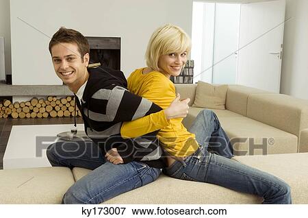 Portrait of a young couple sitting back to back View Large Photo Image Stock Photo - Portrait of a young couple sitting back to back. Fotosearch