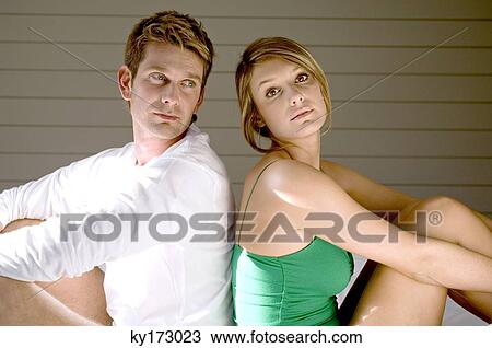 Side profile of a mid adult man and a young woman sitting back to back on the bed View Large Photo Image Stock Image - Side profile of a mid adult man and a young woman sitting back to back on the bed. Fotosearch