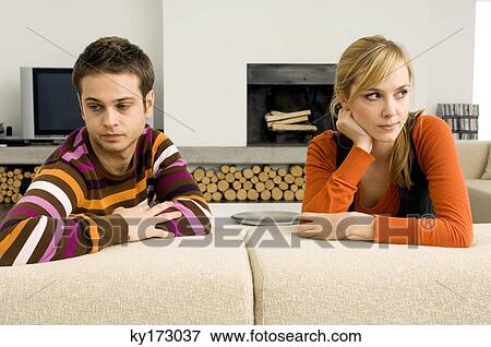 Young couple leaning on a couch and looking serious View Large Photo Image Stock Photo - Young couple leaning on a couch and looking serious. Fotosearch