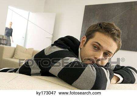 Young man resting in a living room View Large Photo Image Stock Photo - Young man resting in a living room. Fotosearch