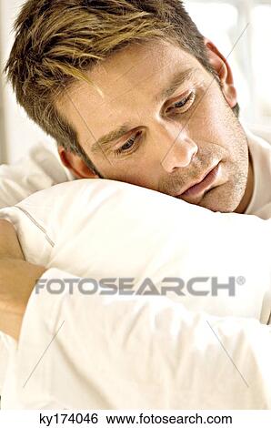 Close-up of a mid adult man hugging a pillow View Large Photo Image Stock Photograph - Close-up of a mid adult man hugging a pillow. Fotosearch