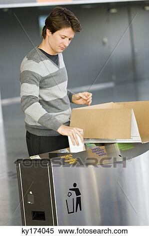 Mid adult man putting garbage into a garbage bin View Large Photo Image Stock Photography - Mid adult man putting garbage into a garbage bin. Fotosearch