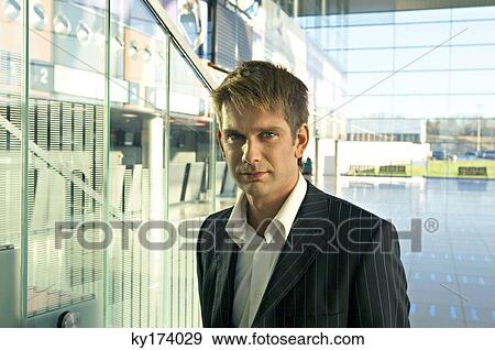 Portrait of a businessman standing at an airport View Large Photo Image Stock Photo - Portrait of a businessman standing at an airport. Fotosearch
