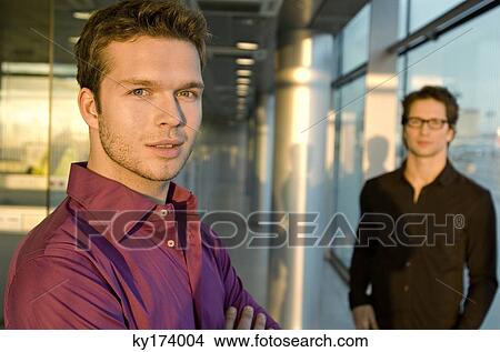 Picture - Portrait of a businessman with another businessman standing behind him. Fotosearch