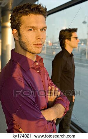 Stock Image - Portrait of a businessman with another businessman standing behind him. Fotosearch