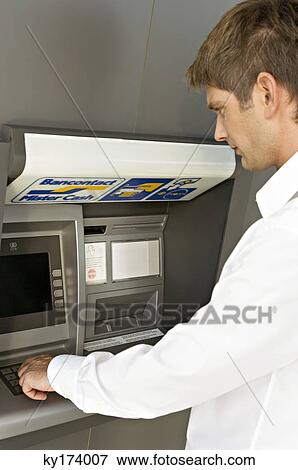 Side profile of a businessman using an ATM View Large Photo Image Stock Photo - Side profile of a businessman using an ATM. Fotosearch