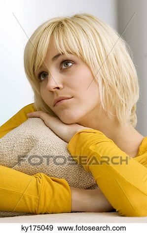 Close-up of a young woman hugging a cushion and thinking View Large Photo Image Stock Photo - Close-up of a young woman hugging a cushion and thinking. Fotosearch