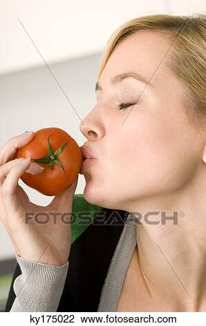 Close-up of a young woman kissing a tomato View Large Photo Image Stock Image - Close-up of a young woman kissing a tomato. Fotosearch