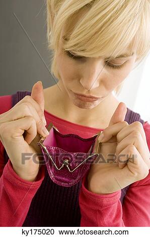 Close-up of a young woman looking into an empty purse View Large Photo Image Stock Image - Close-up of a young woman looking into an empty purse. Fotosearch
