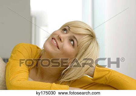 Close-up of a young woman looking upward and smiling View Large Photo Image Stock Image - Close-up of a young woman looking upward and smiling. Fotosearch