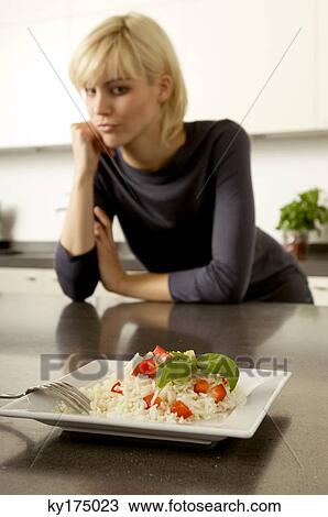 Plate of rice in front of a young woman leaning against a kitchen counter View Large Photo Image Stock Image - Plate of rice in front of a young woman leaning against a kitchen counter. Fotosearch