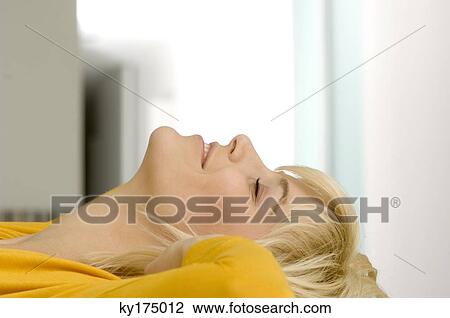 Side profile of a young woman smiling with her eyes closed View Large Photo Image Stock Image - Side profile of a young woman smiling with her eyes closed. Fotosearch