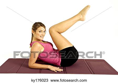 Portrait of a young woman exercising on an exercise mat View Large Photo Image Stock Image - Portrait of a young woman exercising on an exercise mat. Fotosearch