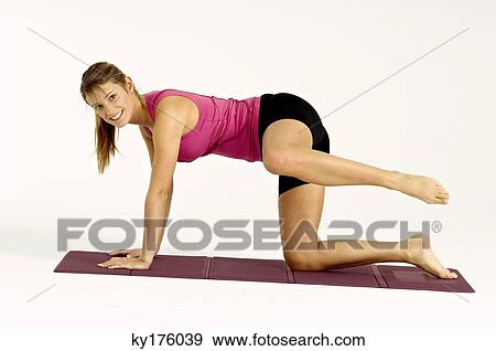 Stock Photo - Portrait of a young woman exercising on an exercise mat. Fotosearch