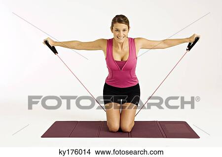 Portrait of a young woman exercising with a resistance band View Large Photo Image Picture - Portrait of a young woman exercising with a resistance band. Fotosearch