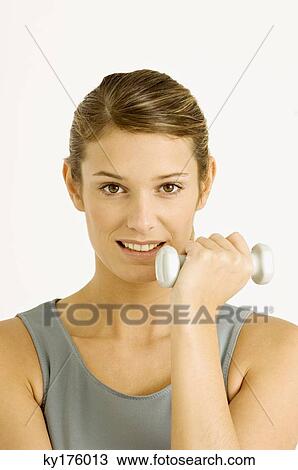 Portrait of a young woman exercising with dumbbells View Large Photo Image Stock Image - Portrait of a young woman exercising with dumbbells. Fotosearch